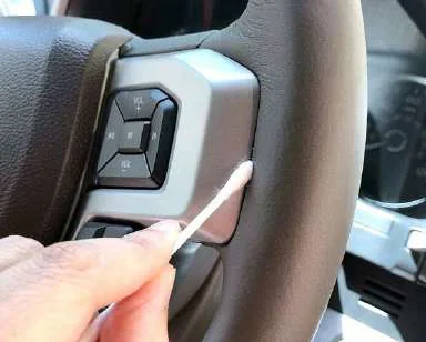 Cleaning a steering wheel with a swab